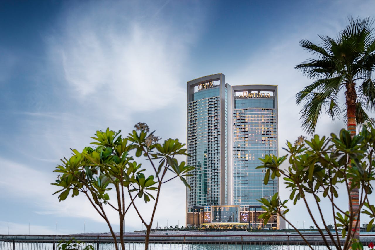 about-02 A breathtaking view of Manama's skyline with prominent towers against a vibrant sky.